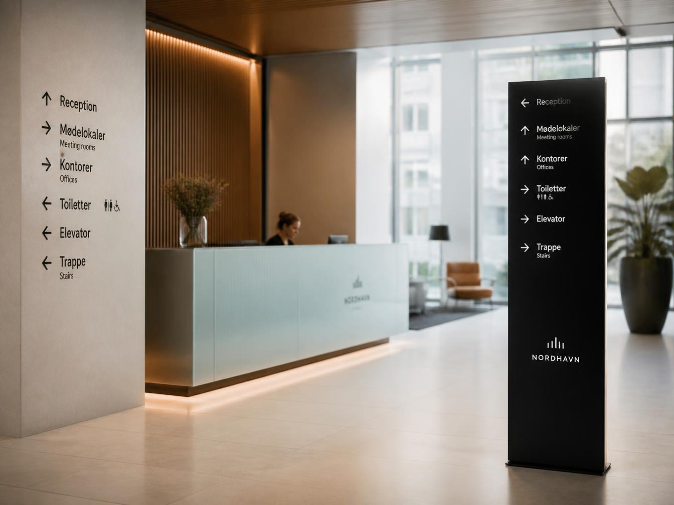Moderne indendørs wayfinding skiltning i kontorlobby med receptionskæde og pylon